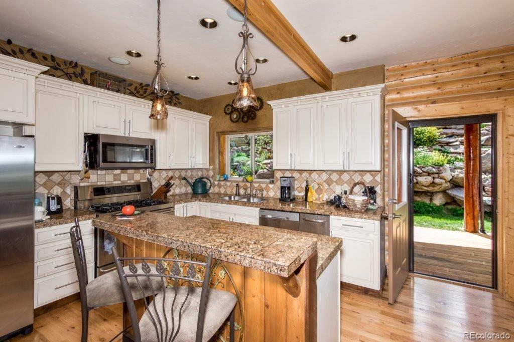 8044 Rossman Gulch Road Morrison, CO 80465 - Photo 16 of 34 a kitchen with stainless steel appliances granite countertop a stove oven and a refrigerator