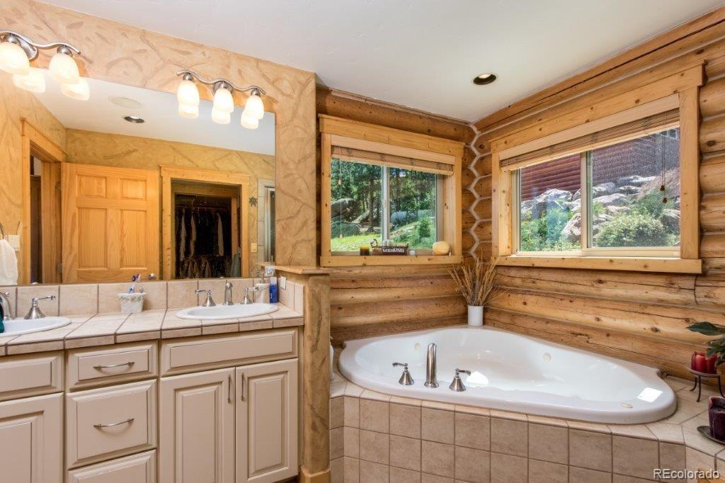 8044 Rossman Gulch Road Morrison, CO 80465 - Photo 21 of 34 a bathroom with a tub a sink and a window