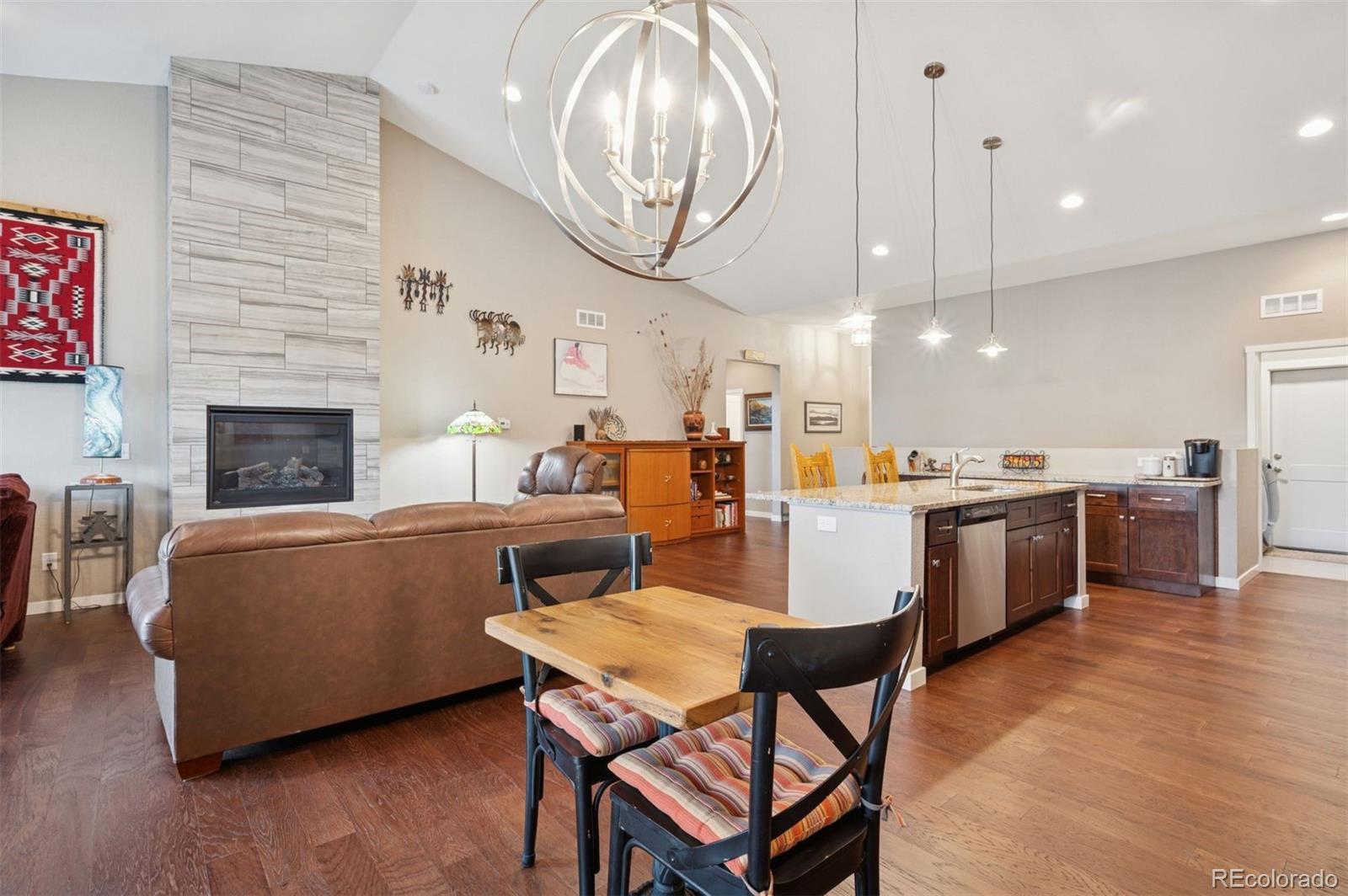 5795 Xenon Way Arvada, CO 80002 - Photo 15 of 33 a living room with stainless steel appliances kitchen island a table chairs and a fireplace