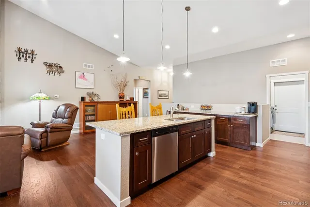 a large kitchen with kitchen island a stove a sink a center island and wooden floor