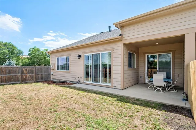 a view of a house with backyard and sitting area