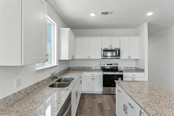 a kitchen with a stove sink and cabinets