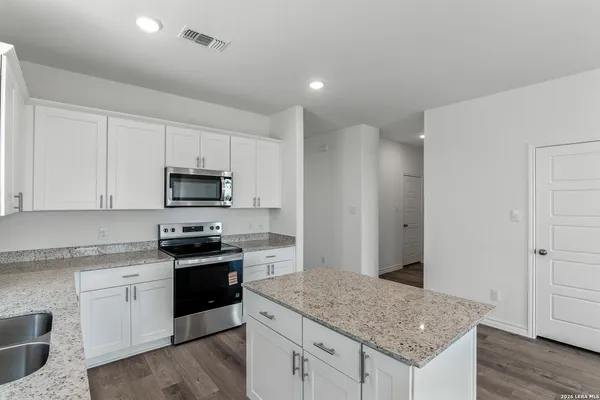 a kitchen with stainless steel appliances granite countertop a stove a sink and a refrigerator