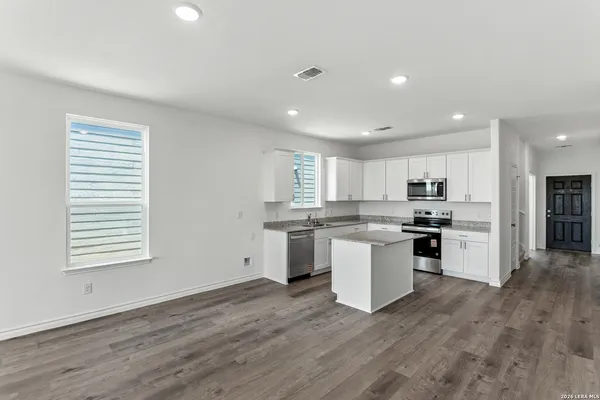a kitchen with a white cabinets and window