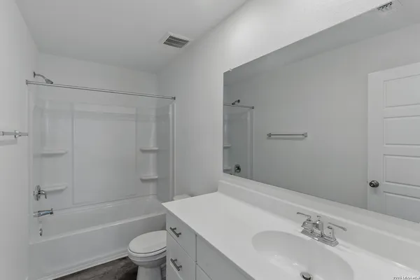 a bathroom with a sink toilet vanity and shower