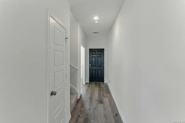 a view of a hallway with wooden floor