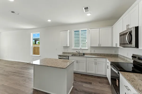 a kitchen with granite countertop a sink and a stove top oven