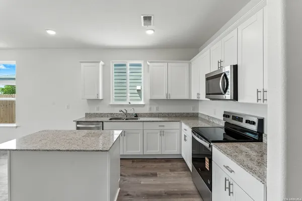 a kitchen with a sink stove top oven and refrigerator