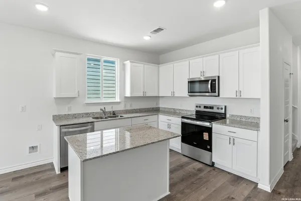 a kitchen with stainless steel appliances granite countertop a stove a sink and a microwave