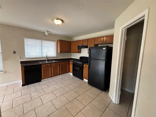 a kitchen with granite countertop a refrigerator and a sink