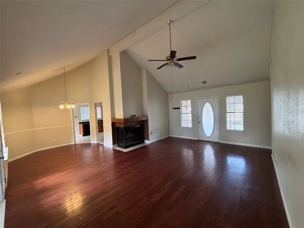 a view of empty room with wooden floor and fireplace