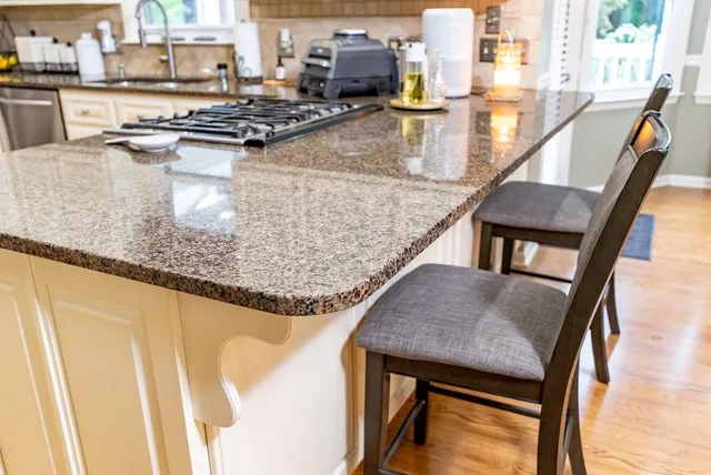 a kitchen with kitchen island a large counter top space and stainless steel appliances