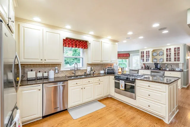 a kitchen with granite countertop white cabinets and white appliances