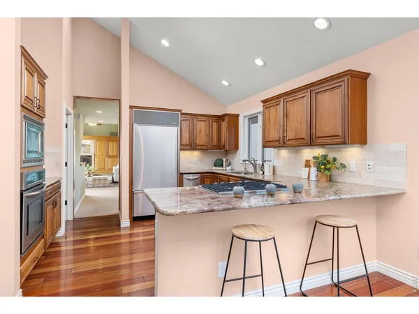 a kitchen with stainless steel appliances kitchen island granite countertop a refrigerator and a stove top oven