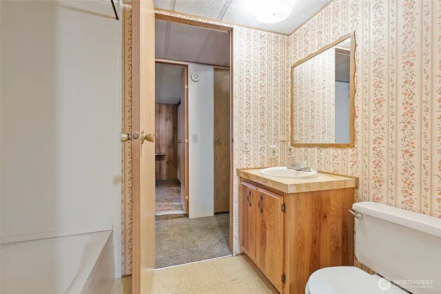 a bed sitting in a spacious bedroom next to a window