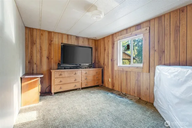 a bedroom with a large bed and a flat tv screen on dresser