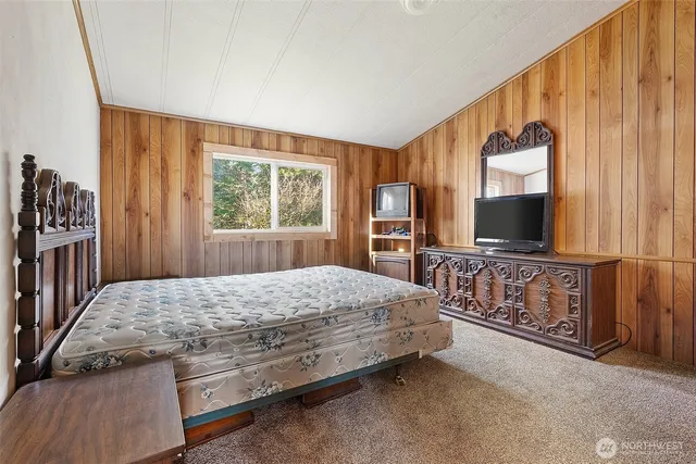 a bedroom with a bed and a dresser with mirror