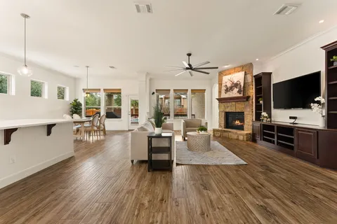 a view of a kitchen with kitchen island a sink a counter top space a large window and stainless steel appliances