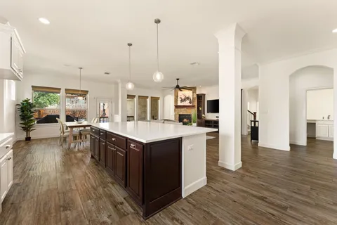 a living room with a flat screen tv a dining table and kitchen view