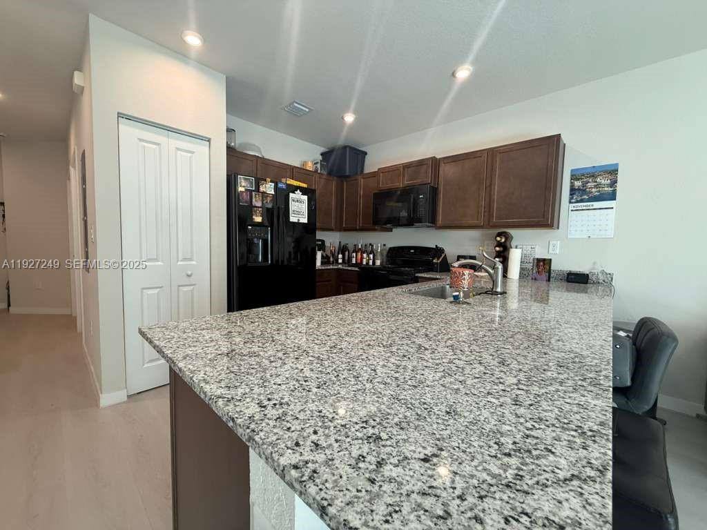 1037 Northwest 5th Street, Unit 1037 Florida City, FL 33034 - Photo 3 of 14 a kitchen with stainless steel appliances granite countertop a sink refrigerator and cabinets