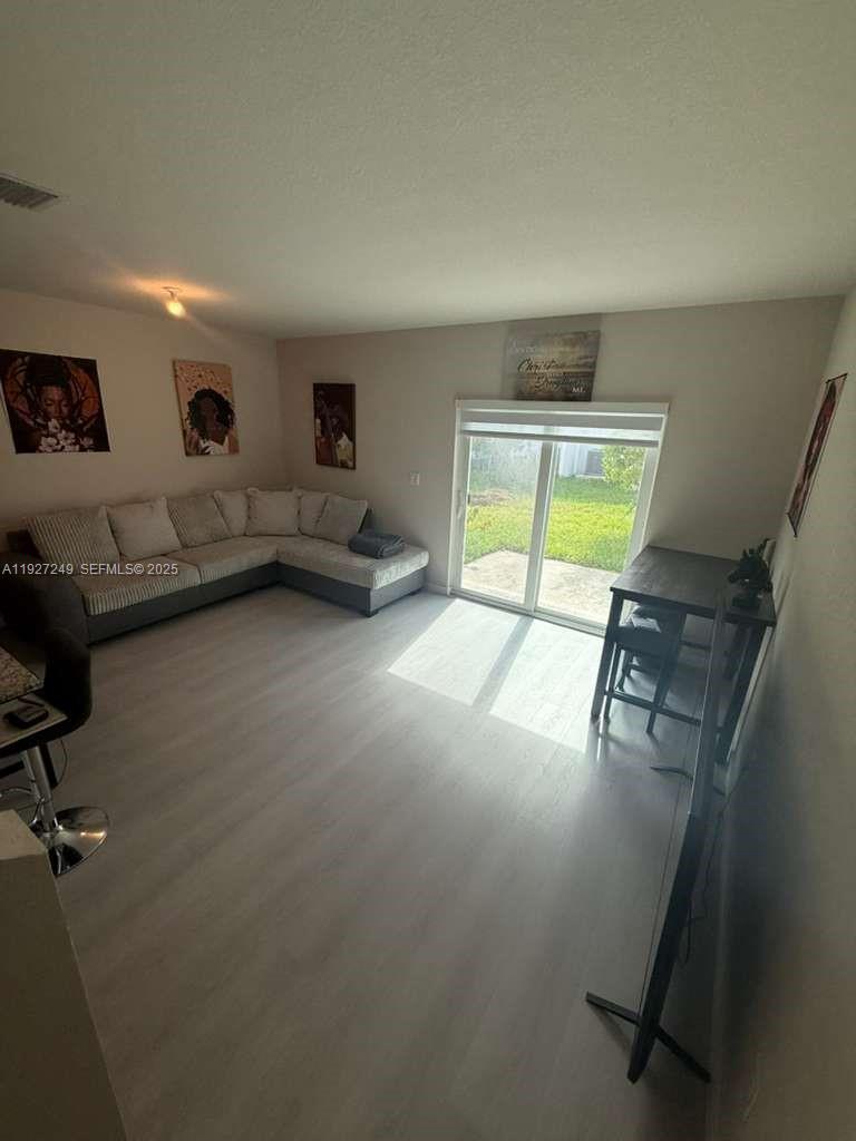 1037 Northwest 5th Street, Unit 1037 Florida City, FL 33034 - Photo 4 of 14 a living room with furniture and a window
