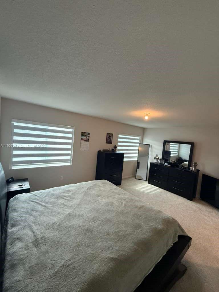 1037 Northwest 5th Street, Unit 1037 Florida City, FL 33034 - Photo 10 of 14 a bedroom with a bed and a view of kitchen