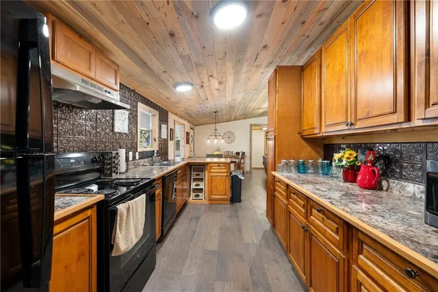 a kitchen with stainless steel appliances granite countertop lots of counter top space and wooden floor