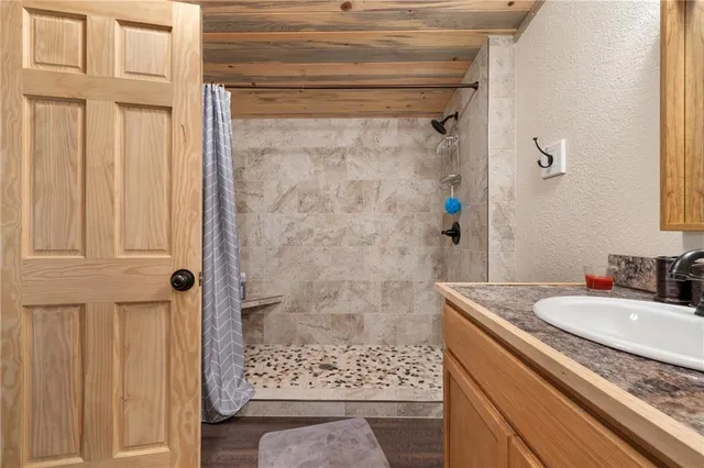 a bathroom with a granite countertop sink a mirror and shower