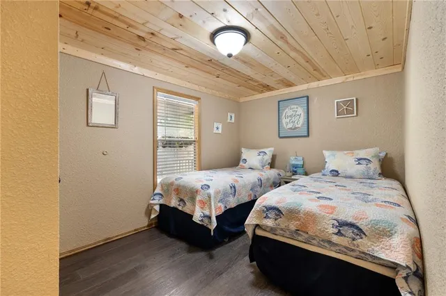 a bedroom with two beds and wooden floor