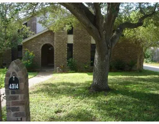 a backyard of a house with a large tree