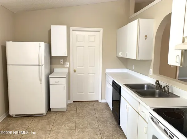 a kitchen with a refrigerator sink stove and cabinets