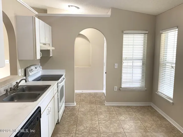 a kitchen with a sink a counter top space and appliances
