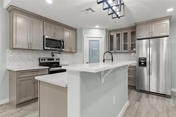 a kitchen with stainless steel appliances a refrigerator sink and microwave