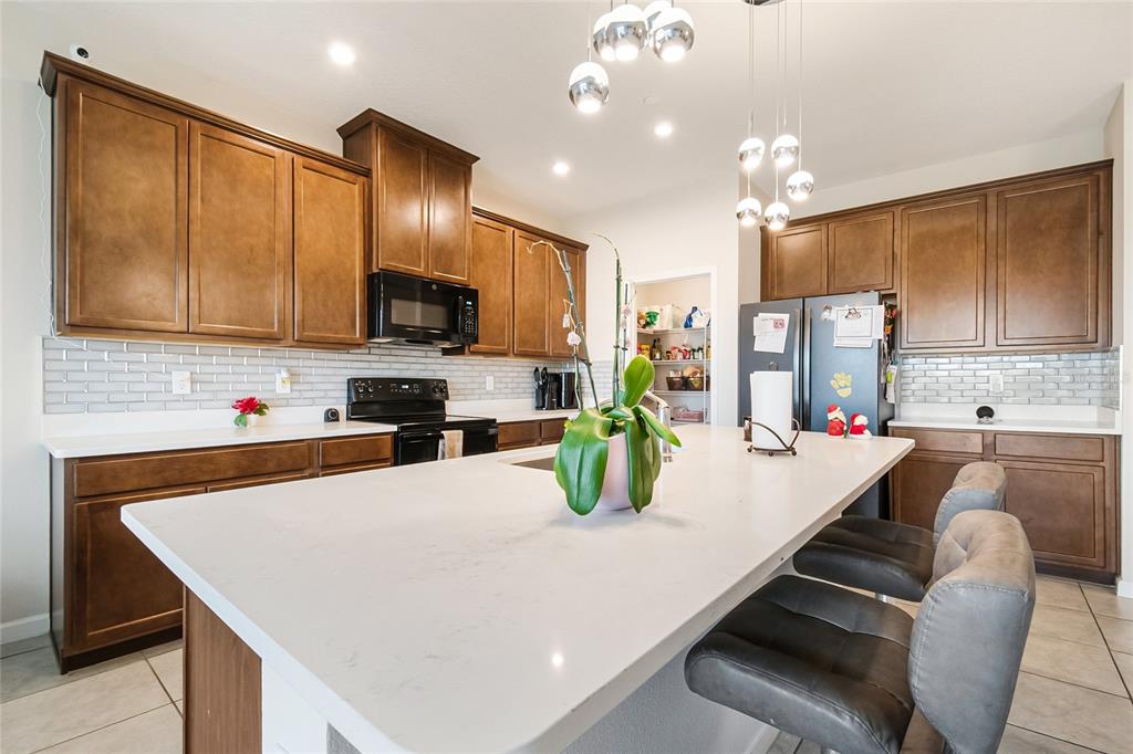 1943 Holden Ridge Ln. Clermont, FL 34715 - Photo 15 of 59 a kitchen with kitchen island granite countertop a sink a counter top space appliances and cabinets