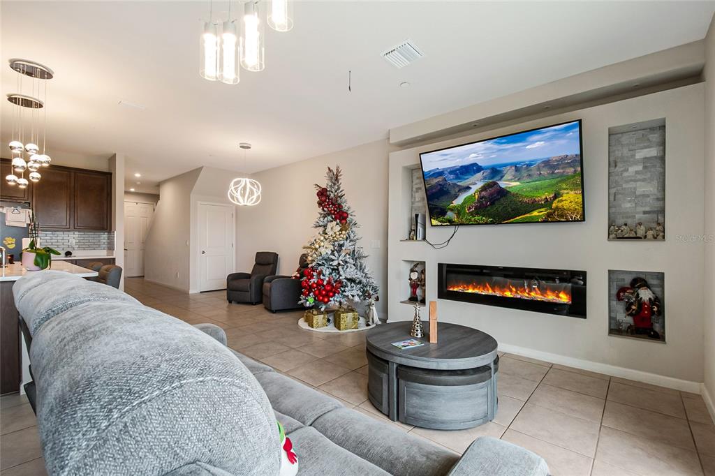 1943 Holden Ridge Ln. Clermont, FL 34715 - Photo 21 of 59 a living room with furniture a flat screen tv and a fireplace