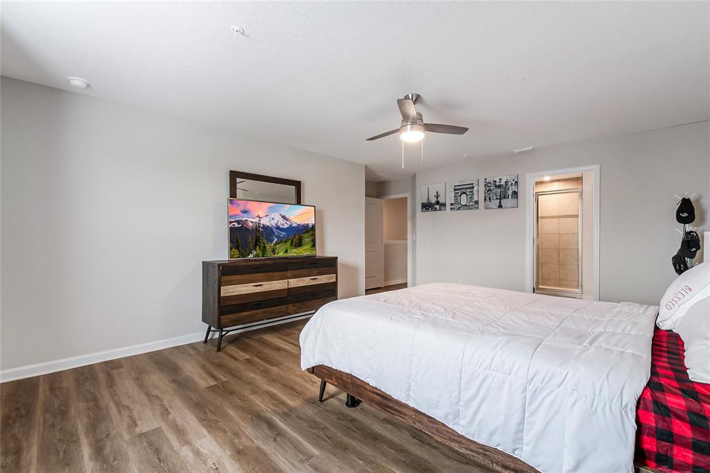 1943 Holden Ridge Ln. Clermont, FL 34715 - Photo 36 of 59 a bedroom with a bed and a flat screen tv
