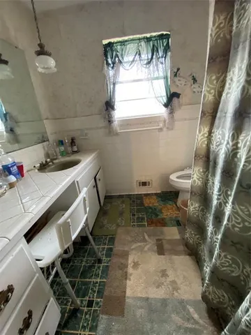a bathroom with a sink toilet and window