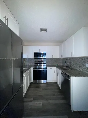 a kitchen with stainless steel appliances granite countertop a sink and stove top oven