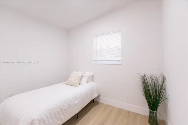 a bedroom with a bed and a potted plant