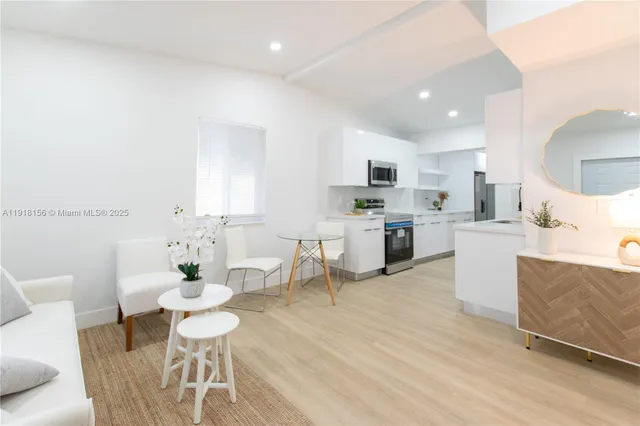 a living room with furniture a dining table and kitchen view
