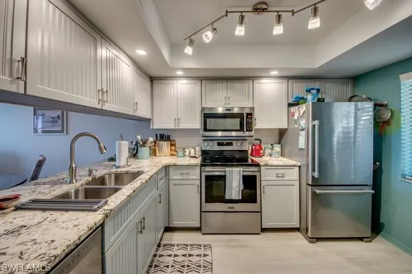 a kitchen with stainless steel appliances granite countertop a sink refrigerator and microwave
