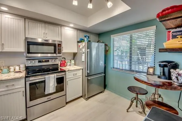 a kitchen with stainless steel appliances granite countertop a stove a sink dishwasher a refrigerator and a microwave