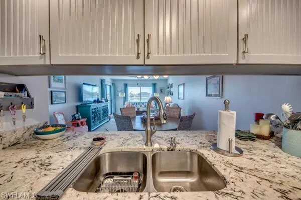 a kitchen with granite countertop a sink and a white cabinets