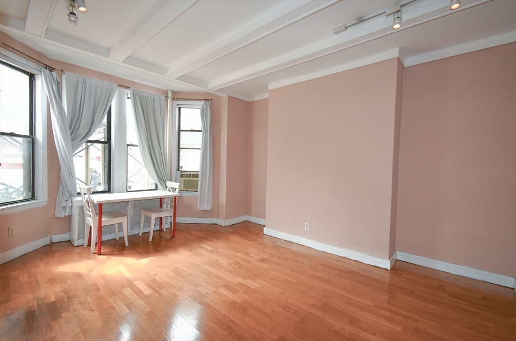 an empty room with wooden floor and furniture