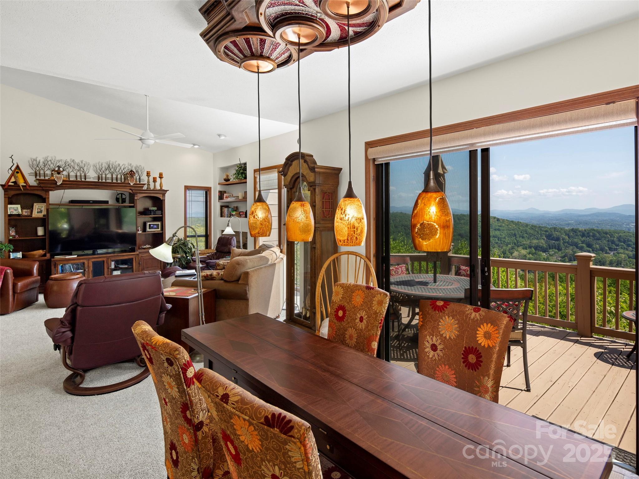 167 Country Ridge Road Laurel Park, NC 28739 - Photo 12 of 27 a living room with furniture a chandelier and a floor to ceiling window