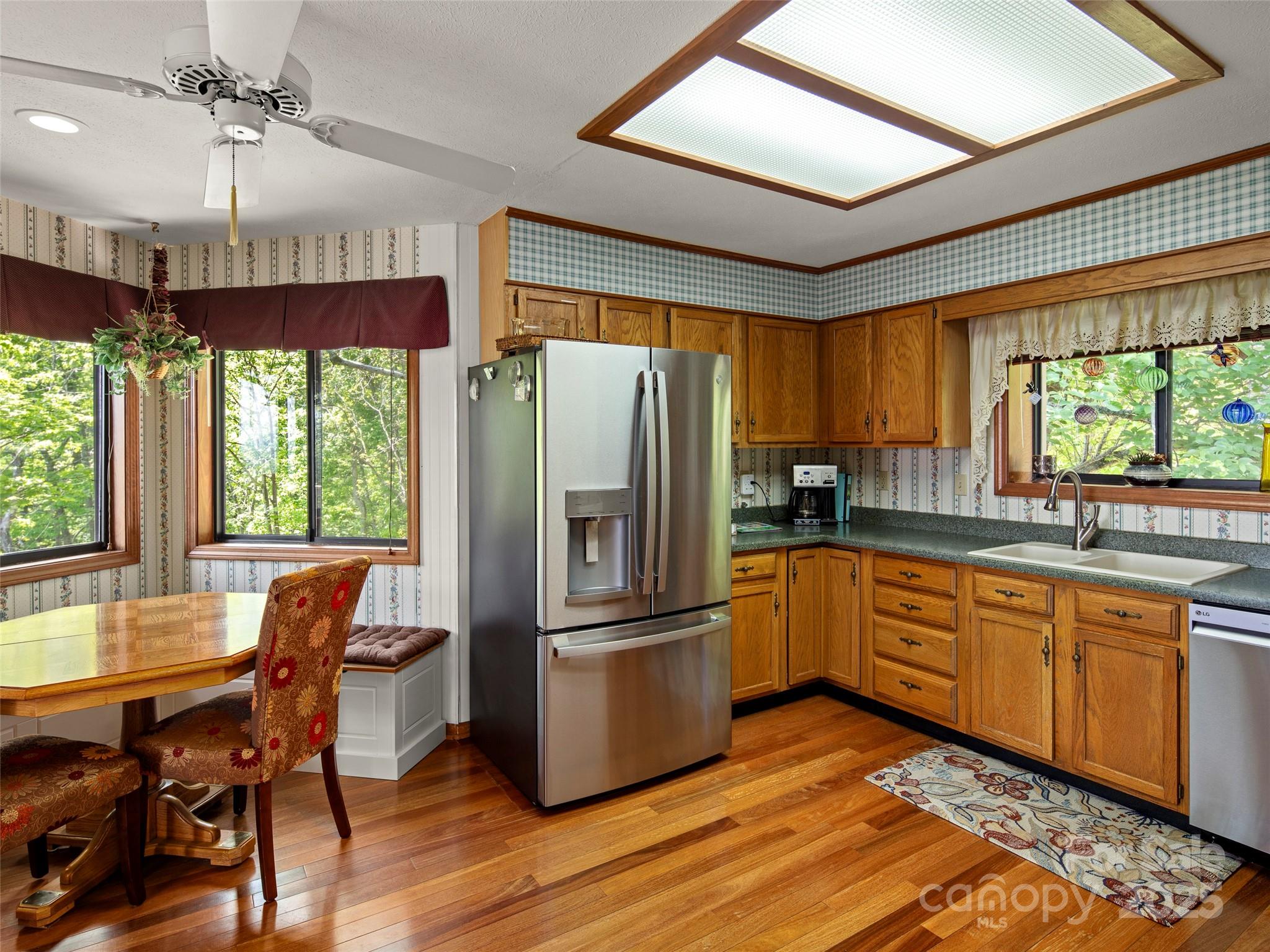 167 Country Ridge Road Laurel Park, NC 28739 - Photo 15 of 27 a kitchen with stainless steel appliances granite countertop a refrigerator a sink dishwasher a stove and white countertops with wooden floor