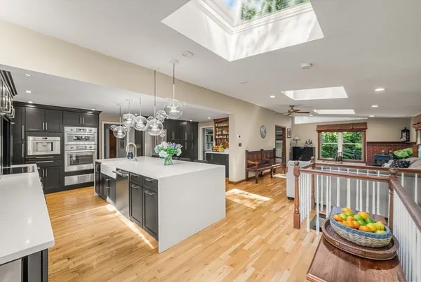 a large white kitchen with lots of counter space and stainless steel appliances
