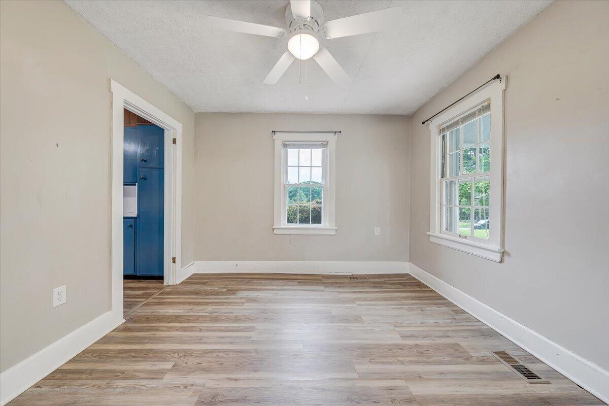 1384 Thaxton Mountain Road Thaxton, VA 24174 - Photo 9 of 44 an empty room with wooden floor chandelier fan and windows