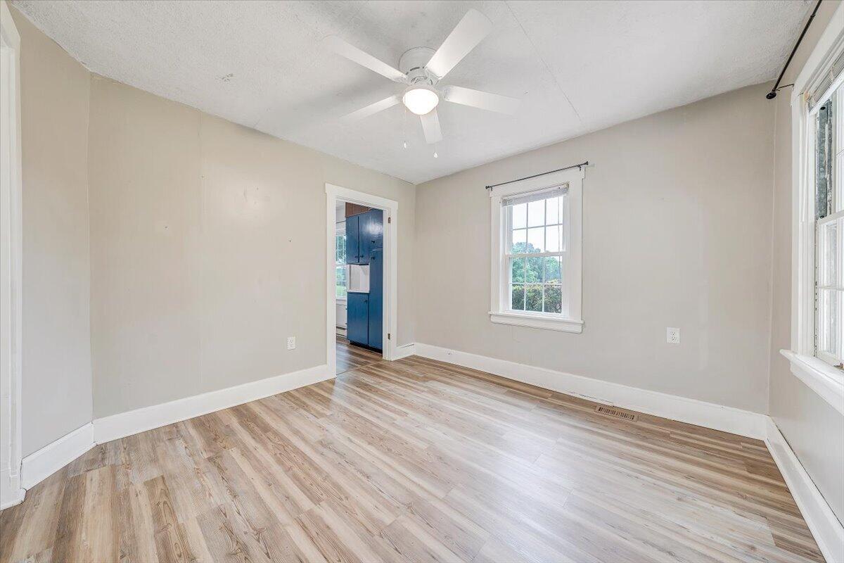 1384 Thaxton Mountain Road Thaxton, VA 24174 - Photo 10 of 44 an empty room with wooden floor chandelier fan and windows