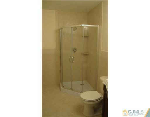 128 Idlewild Road Edison, NJ 08817 - Photo 4 of 9 a bathroom with a granite countertop toilet sink and a shower